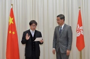 The new Secretary for Labour and Welfare, Mr Stephen Sui (left), takes the oath of office, witnessed by the Chief Executive, Mr C Y Leung (right).