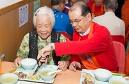 張建宗（右）為一名長者剪碎餸菜。