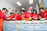 Mr Cheung (fourth left) joins other guests to prepare a meal for the elderly in a community canteen.