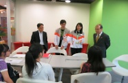 Mr Cheung (first right) is briefed on the career consultation services provided to young people and chats with secondary students taking part in a Junior Career Planner Contest.