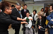 The Secretary for Labour and Welfare, Dr Law Chi-kwong, visited Sai Kung District and called at the wheelchair repair centre of the Direction Association for the Handicapped. Photo shows (second row, from first left) Dr Law; the Under Secretary for Labour and Welfare, Mr Caspar Tsui; and the District Social Welfare Officer (Wong Tai Sin/Sai Kung), Ms Micy Lui, being introduced to mock equipment designed by volunteers for persons with disabilities to enjoy wargaming.