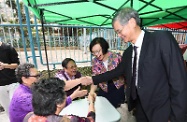 The Secretary for Home Affairs, Mr Lau Kong-wah; the Secretary for Labour and Welfare, Dr Law Chi-kwong; and the Secretary for Food and Health, Professor Sophia Chan, visited Kwai Tsing District. Photo shows Dr Law (first right) and Professor Chan (second right) visiting a pop-up health checkup station of the "Project e+: Dementia Community Support Service" and chatting with residents.