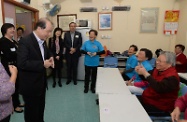 Accompanied by Mrs Choi (fourth left) and the Chairman of Sik Sik Yuen, Mr Wong Kam-choi (fifth left), Mr Cheung (third left) practices sign language with the demonstrator at the centre's sign language class.