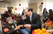 The Secretary for Labour and Welfare, Mr Matthew Cheung Kin-chung, visited a nursing home cum day care centre in Kwai Chung to extend his Lunar New Year greetings to the elderly. Photo shows Mr Cheung presenting mandarins to the senior residents.