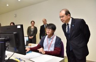 Mr Cheung (first right) listens carefully to a staff member of the Operation Team explaining the process of handling LIFA applications.