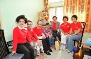 Mr Cheung (third left), together with Dr Cheng (third right) and others visiting the home of an elderly and present a festive gift pack to her.