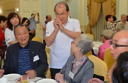 张建宗（中）向出席茶敍活动的长者致意，感谢他们对香港发展作出的贡献。