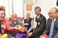 The Secretary for Labour and Welfare, Dr Law Chi-kwong, visited Kwun Tong District to pay home visits. Photo shows Dr Law (second right) presenting an elderly couple with a gift pack.
