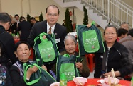 Mr Cheung (second left) distributes souvenir packs to participating elderly persons, and wishes them a happy Chinese New Year.