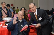 Mr Cheung (right) gives a souvenir scarf to a participating elderly person.