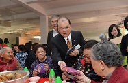 Mr Cheung (centre) distributes souvenir scarves to participating elderly persons.