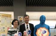 The Secretary for Labour and Welfare, Dr Law Chi-kwong, joins the Secretary for Food and Health, Professor Sophia Chan, and "Anyone" from the Fire Services Department to appeal to colleagues for supporting organ donation at a promotion booth in Central Government Offices.