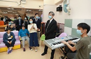 The Secretary for Labour and Welfare, Dr Law Chi-kwong, visited Southern District and called at the TWGHs Jockey Club Rehabilitation Complex in Aberdeen. Photo shows Dr Law (second right) and clients watching a musician who is visiting Hong Kong and playing at the centre.