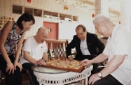 Mr Cheung (second right) and Ms Yip (first left) watch two elderly people play chess at the aged home.