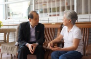 Mr Cheung (left) introduces to an elderly person the Guangdong Scheme, which will be implemented on October 1.
