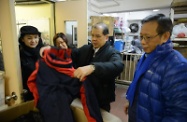 Mr Cheung (second right) inspects the warm clothing and sundry supplies for street sleepers.