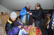 Mr Cheung (first right) helping a street sleeper to put on a scarf.