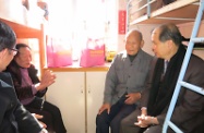 Accompanied by Kwun Tong District Council members and volunteers, the Secretary for Labour and Welfare, Mr Matthew Cheung Kin-chung (first right), visits elderly people in Kwun Tong and presents them with gift packs.