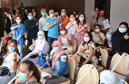 The Secretary for the Civil Service, Mr Patrick Nip, and the Secretary for Labour and Welfare, Dr Law Chi-kwong, viewed the administering of the Sinovac vaccine to Indonesians staying in Hong Kong by the Government's outreach vaccination team at a hotel in Causeway Bay today (August 1). Photo shows they and the Indonesians, as well as the medical team responsible for the vaccination outreach service today, showing their support for the COVID-19 Vaccination Programme.