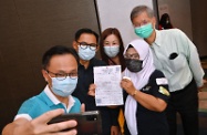 The Secretary for the Civil Service, Mr Patrick Nip, and the Secretary for Labour and Welfare, Dr Law Chi-kwong, viewed the administering of the Sinovac vaccine to Indonesians staying in Hong Kong by the Government's outreach vaccination team at a hotel in Causeway Bay today (August 1). Photo shows Mr Nip (first left), Dr Law (first right) and the Consul General of the Republic of Indonesia in Hong Kong, Mr Ricky Suhendar (second left) taking a selfie with an Indonesian (second right) after vaccination.