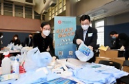 Secretaries of Departments and Directors of Bureaux today (March 30) visited packaging centres for anti-epidemic service bags in several districts, giving encouragement to participating civil servants from their teams and volunteers from all sectors. The Secretary for Labour and Welfare, Dr Law Chi-kwong, led his team to join the packaging work at Chun Wah Road Sports Centre. Photo shows the Permanent Secretary for Labour and Welfare, Ms Alice Lau (front row, left); and the Commissioner for Labour, Mr Chris Sun (front row, right).