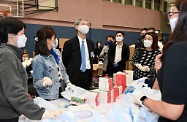 Secretaries of Departments and Directors of Bureaux today (March 30) visited packaging centres for anti-epidemic service bags in several districts, giving encouragement to participating civil servants from their teams and volunteers from all sectors. The Secretary for Labour and Welfare, Dr Law Chi-kwong, led his team to join the packaging work at Chun Wah Road Sports Centre. Photo shows Dr Law chatting with and showing his support to participating colleagues.