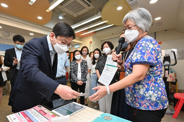 The Secretary for Labour and Welfare, Mr Chris Sun, visited the H.K.S.K.H. Chuk Yuen Canon Martin District Elderly Community Centre in Wong Tai Sin this afternoon (August 3) to learn more about the daily needs of elderly people and the diversified services of the centre. Photo shows Mr Sun (front row, left) being briefed by an elderly person on the use of mobile application for remote monitoring of health conditions.