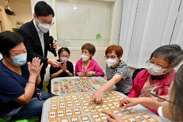 The Secretary for Labour and Welfare, Mr Chris Sun, visited the H.K.S.K.H. Chuk Yuen Canon Martin District Elderly Community Centre in Wong Tai Sin this afternoon (August 3) to learn more about the daily needs of elderly people and the diversified services of the centre. Photo shows Mr Sun (second left) joining elderly people in a card game on emotions developed by the centre.