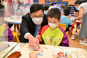 The Secretary for Labour and Welfare, Mr Chris Sun; the Permanent Secretary for Labour and Welfare, Ms Alice Lau; and the Director of Social Welfare, Miss Charmaine Lee, visited Po Leung Kuk Wai Yin Kindergarten-Cum-Nursery this morning (August 23) to learn more about the effectiveness and implementation of the On-site Pre-school Rehabilitation Services. Photo shows Mr Sun (left) joining a child drawing in the visual arts training zone.