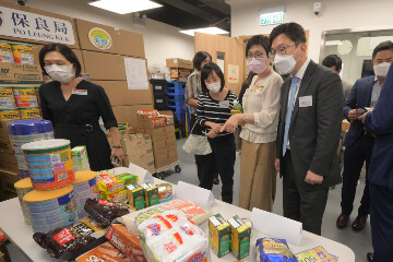 The Secretary for Labour and Welfare, Mr Chris Sun, visited the service centre of Blue Sky Short-term Food Assistance Service Team of Po Leung Kuk (PLK) in Yuen Long this afternoon (August 30) to take a closer look at the latest situation after its regularisation from August 2021. The Director of Social Welfare, Miss Charmaine Lee, also joined the visit. Photo shows Mr Sun (front row, first right) and Miss Lee (front row, third right) being briefed by the Chief Executive Officer of PLK, Ms Anissa Wong (front row, second right), on the various types of assistance provided by the Service Team.