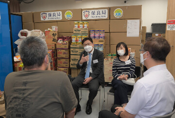 The Secretary for Labour and Welfare, Mr Chris Sun, visited the service centre of Blue Sky Short-term Food Assistance Service Team of Po Leung Kuk in Yuen Long this afternoon (August 30) to take a closer look at the latest situation after its regularisation from August 2021. The Director of Social Welfare, Miss Charmaine Lee, also joined the visit. Photo shows Mr Sun (left) and Miss Lee (right) listening to a frontline worker speaking on how the Short-term Food Assistance Service Team catered for his temporary daily needs.