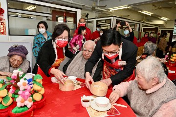 The Secretary for Labour and Welfare, Mr Chris Sun, officiated at the launch ceremony of setting up a “mobile Chinese restaurant“ in residential care homes for the elderly (RCHEs) this afternoon (January 27), a major item of the Great Fun Ageing - Elderly and Carer Support Services project funded by the Partnership Fund for the Disadvantaged of the Social Welfare Department. The “mobile Chinese restaurant“ enables elderly persons with swallowing difficulties in RCHEs to enjoy soft meals simulating the forms of dim sum. The Permanent Secretary for Labour and Welfare, Ms Alice Lau, also officiated at the ceremony. Photo shows Mr Sun (second right) delivering a dim sum combo simulating shrimp dumpling and siu mai to an elderly person.