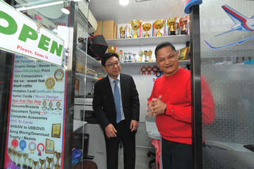 The Secretary for Labour and Welfare, Mr Chris Sun, visited the Yau Tsim Mong Multicultural Activity Centre of the New Home Association in Jordan yesterday afternoon (March 6) to take a closer look at its service of the Racial Diversity Employment Programme commissioned by the Labour Department. The Commissioner for Labour, Ms May Chan, also joined the visit. Photo shows Mr Sun (left) in a shop in the centre employing ethnic minorities. The shop provides design and printing services, as well as immigration advice to ethnic minorities.