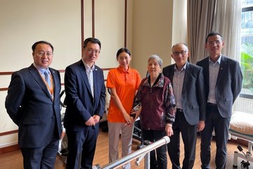 勞工及福利局副局長何啟明今日(四月二十七日)考察廣州的安老院。圖示何啟明(左二)及社會福利署助理署長(安老服務)陳德義(右二)與一名到廣州就讀護理課程的香港學生合照。