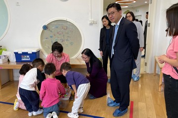 The Secretary for Labour and Welfare, Mr Chris Sun, today (May 9) continued his visit in Beijing. The Permanent Secretary for Labour and Welfare, Ms Alice Lau, also joined the visit. Photo shows Mr Sun (standing, second right) and Ms Lau (kneeling, first right) watching children receiving care services while playing, during their visit to an occasional child care facility in Beijing this morning.