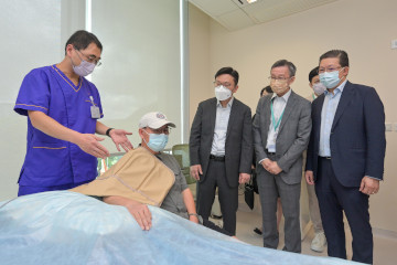 勞工及福利局局長孫玉菡今日(八月二十二日)到訪香港中文大學醫院(中大醫院),視察「工傷僱員復康先導計劃」的進展。勞工處於二○二二年九月推出先導計劃,以個案管理模式為建造業工傷僱員提供快捷和優質的私家門診復康治療服務。圖示孫玉菡(中)在中大醫院執行董事及行政總裁馮康醫生(右二)及服務承辦機構盈健醫療集團有限公司主席兼行政總裁陳健平(右一)陪同下,聽取物理治療師介紹治療過程,以及如何協助工傷僱員早日康復並重投工作。