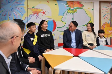 政務司司長陳國基今日(十二月七日)到訪位於深水埗的聖公會聖安德烈小學,視察在校課後託管服務計劃的推行情況。勞工及福利局局長孫玉菡和署理教育局局長施俊輝亦有隨行。圖示陳國基(右三)與學童和家長交流,欣悉家長重投職場。