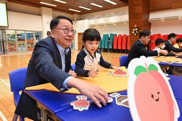 政務司司長陳國基今日(十二月七日)到訪位於深水埗的聖公會聖安德烈小學,視察在校課後託管服務計劃的推行情況。勞工及福利局局長孫玉菡和署理教育局局長施俊輝亦有隨行。圖示陳國基(左一)在禮堂與學童一同參與小組遊戲,紓緩學習壓力。
