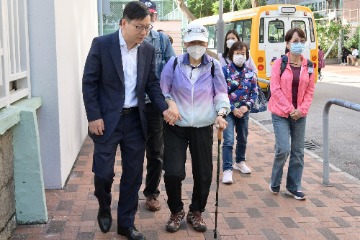 勞工及福利局局長(勞福局)孫玉菡今日(十二月十日)上午率領勞福局及社會福利署(社署)義工隊到訪荃灣樂善堂尹立強敬老鄰舍中心,視察社署一筆過資助長者中心提供便利長者於二○二三年區議會一般選舉投票措施。圖示孫玉菡(前排左)陪伴長者前往票站。