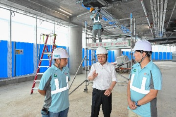The Secretary for Labour and Welfare, Mr Chris Sun (centre), visits a construction site today (December 13) to call on workers to pay attention to work safety.
