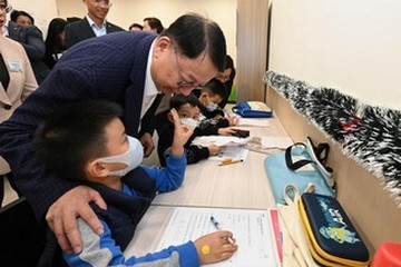 The Chief Secretary for Administration and Chairperson of the Commission on Poverty, Mr Chan Kwok-ki, today (December 18) visited the Sham Shui Po Community Living Room, the first project under the Pilot Programme on Community Living Room. The Secretary for Labour and Welfare, Mr Chris Sun, also joined the visit. Photo shows Mr Chan (standing, first left) chatting with children doing homework in the study room.