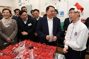 政務司司長兼扶貧委員會主席陳國基今日(十二月十八日)視察深水埗社區客廳,是「社區客廳試行計劃」首個項目。勞工及福利局局長孫玉菡亦有隨行。圖示陳國基(前排右二)和孫玉菡(前排右三)參觀共享備餐間,觀看「劏房」戶製作聖誕食品。