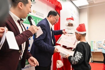 The Chief Secretary for Administration and Chairperson of the Commission on Poverty, Mr Chan Kwok-ki, today (December 18) officiated at the Sham Shui Po Community Living Room Opening Ceremony, the first project under the Pilot Programme on Community Living Room. The Secretary for Labour and Welfare, Mr Chris Sun, also attended. Photo shows Mr Chan (second left) playing games with a child.