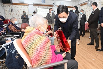 勞工及福利局局長孫玉菡今日(十二月二十日)到訪上環一間安老院,了解院舍外展疫苗接種服務特別計劃的推行情況。圖示孫玉菡(右)向長者送上節日禮物,預祝冬至及聖誕新年快樂。
