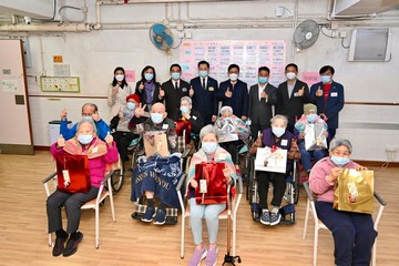 勞工及福利局局長孫玉菡今日(十二月二十日)到訪上環一間安老院,了解院舍外展疫苗接種服務特別計劃的推行情況。圖示孫玉菡(站立,右四)和東華三院主席韋浩文(站立,左四)與準備接種疫苗的院友合照。