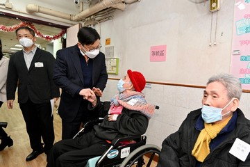 勞工及福利局局長孫玉菡今日(十二月二十日)到訪上環一間安老院,了解院舍外展疫苗接種服務特別計劃的推行情況。圖示孫玉菡(左二)為院友打氣,呼籲他們適時接種新冠及流感疫苗,加強個人保護。
