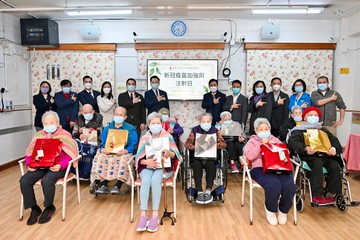 The Secretary for Labour and Welfare, Mr Chris Sun, today (December 20) visited a residential care home for the elderly in Sheung Wan to view the implementation of the outreach vaccination service special programme for residential care homes. Photo shows Mr Sun (standing, sixth right), the Chairman of the Tung Wah Group of Hospitals, Mr Herman Wai (standing, sixth left), and residents about to receive vaccination.