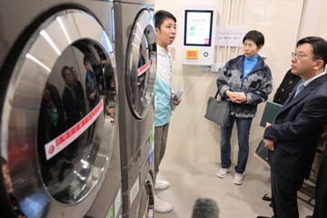 The fifth-term Commission on Poverty today (January 4) visited the first project under the Pilot Programme on Community Living Room, the Sham Shui Po Community Living Room. The Secretary for Labour and Welfare, Mr Chris Sun, also joined the visit. Photo shows Mr Sun (right) and members looking at the self-service laundry, which provides convenience to sub-divided unit households.