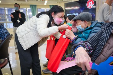 勞工及福利局（勞福局）局長孫玉菡今日（一月二十七日）率領勞福局及社會福利署（社署）義工隊探訪沙田一間安老院，並向長者拜早年。勞福局常任秘書長劉焱亦有同行。圖示劉焱（左）向長者送上福袋。