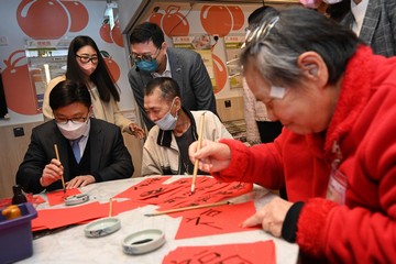 勞工及福利局局長孫玉菡今日（二月七日）視察古洞北福利服務綜合大樓。大樓以「組裝合成」建築法興建，為長者和殘疾人士提供院舍和社區照顧服務，其中全部七間安老院自去年八月起啓用。勞工及福利局常任秘書長劉焱亦有隨行。圖示孫玉菡（前排左）到訪其中一間安老院，並與院友寫揮春。